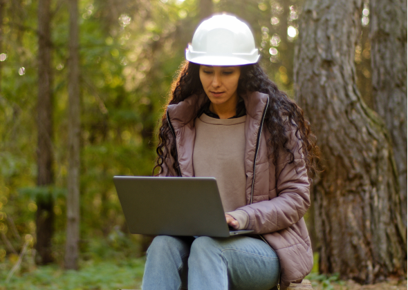 Environmentalist sits outside with their laptop